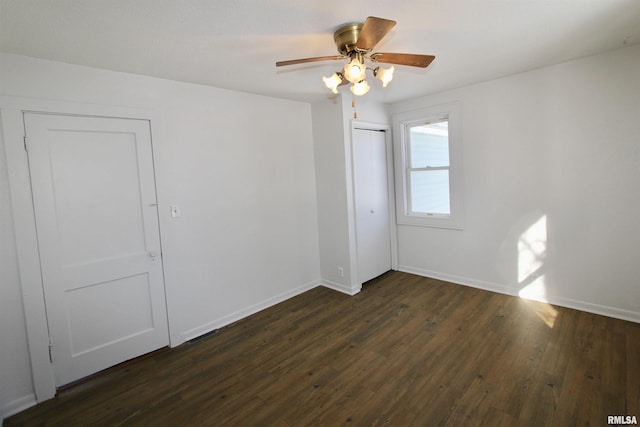 empty room with ceiling fan and dark wood-type flooring