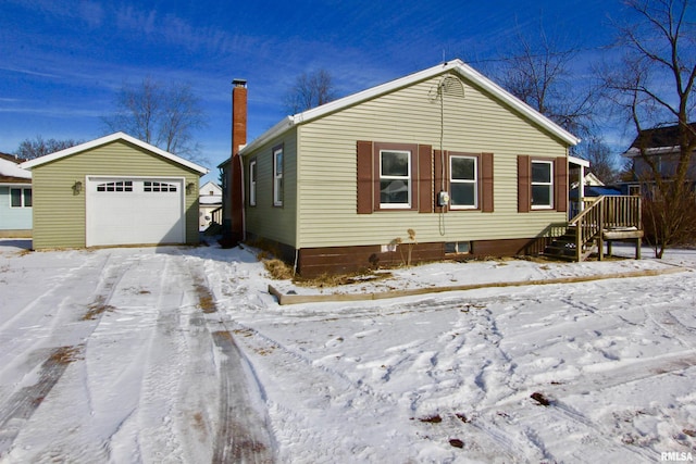 view of front of home with a garage and an outbuilding