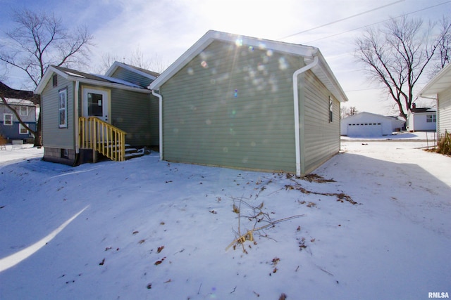 view of snow covered rear of property