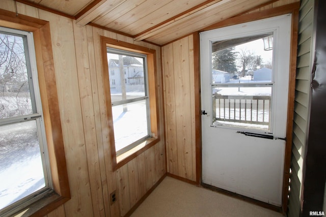 doorway to outside with lofted ceiling, wooden walls, and wood ceiling