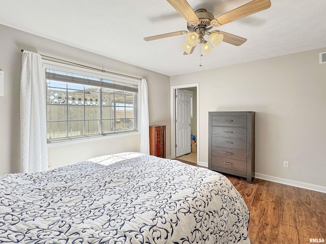 bedroom featuring visible vents, ceiling fan, baseboards, and wood finished floors