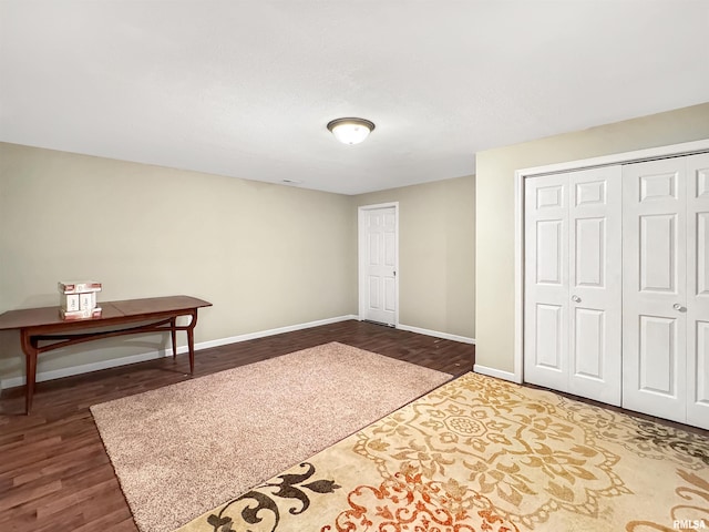 interior space with dark wood-type flooring and baseboards