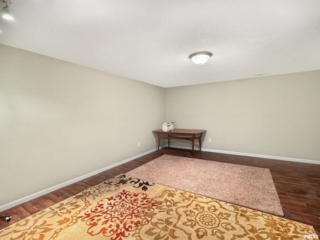 unfurnished room featuring dark wood finished floors and baseboards