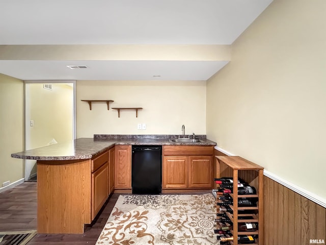 bar with dark wood-style flooring, a sink, visible vents, dishwasher, and indoor wet bar