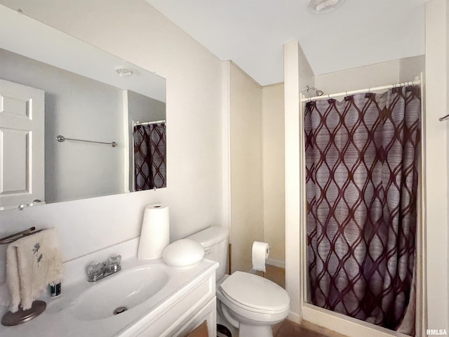 bathroom with curtained shower, vanity, and toilet