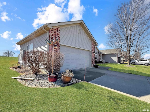 view of side of property with a garage, driveway, brick siding, and a lawn