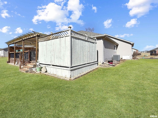 view of side of home featuring a yard and central AC unit