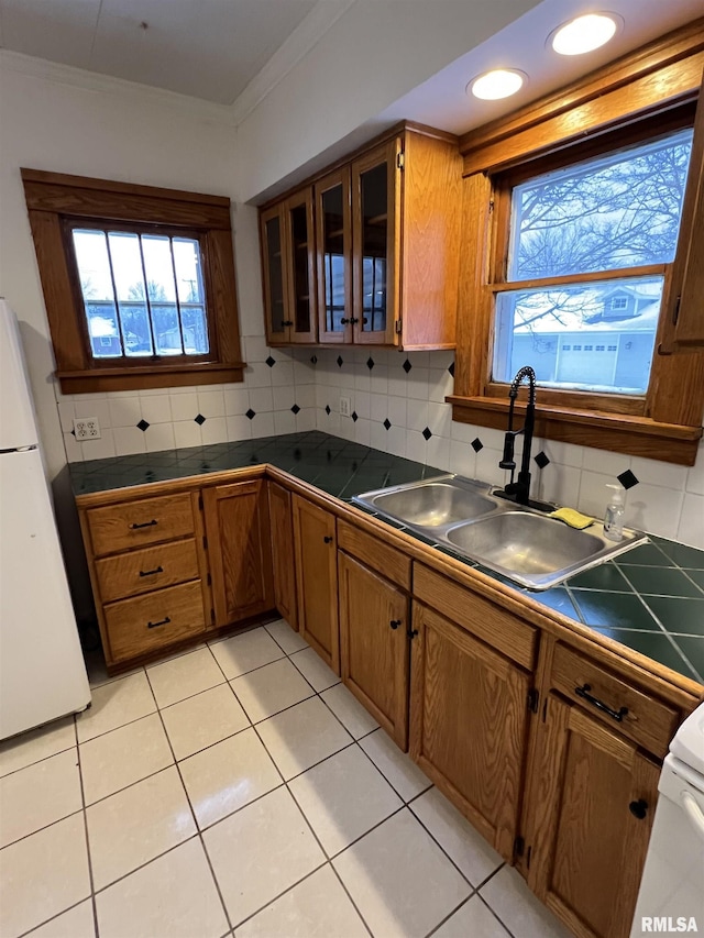 kitchen with sink, white refrigerator, decorative backsplash, and light tile patterned floors