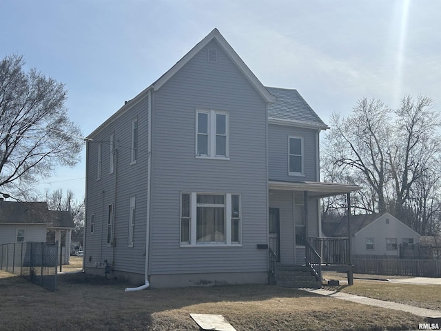 view of front of house with a front lawn, fence, and covered porch