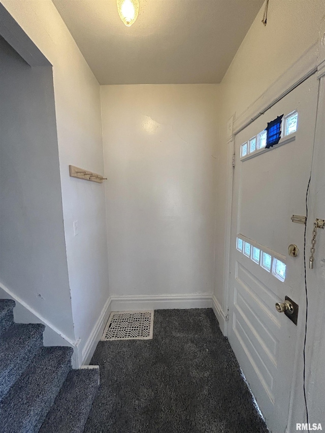 carpeted foyer featuring visible vents, stairs, and baseboards