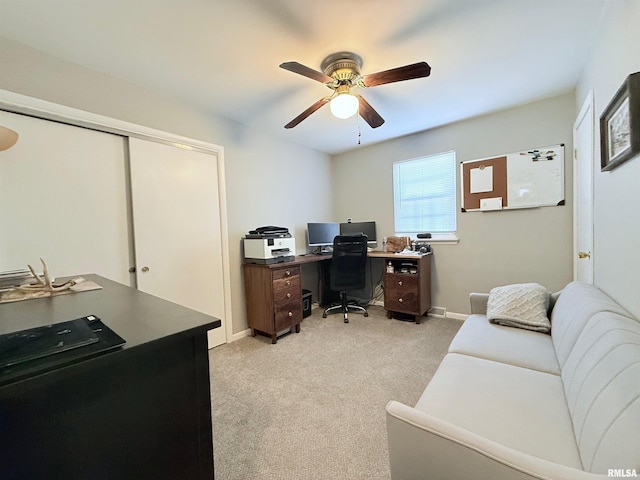 office space featuring light carpet and ceiling fan