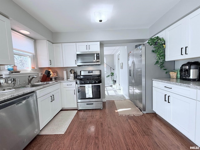 kitchen with white cabinetry, appliances with stainless steel finishes, sink, and dark hardwood / wood-style flooring