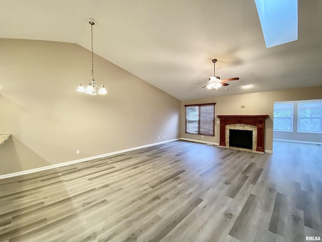 unfurnished living room featuring lofted ceiling, hardwood / wood-style floors, and ceiling fan with notable chandelier