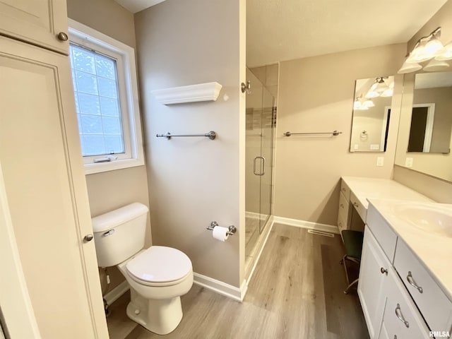 bathroom with hardwood / wood-style floors, toilet, an enclosed shower, and vanity