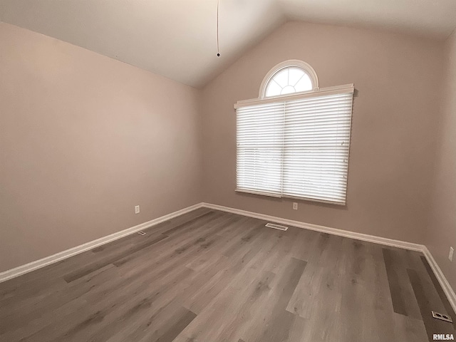 unfurnished room featuring hardwood / wood-style flooring and lofted ceiling