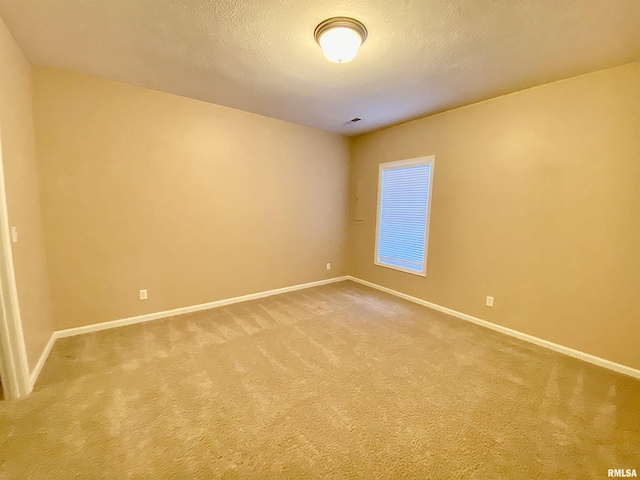 carpeted spare room with a textured ceiling