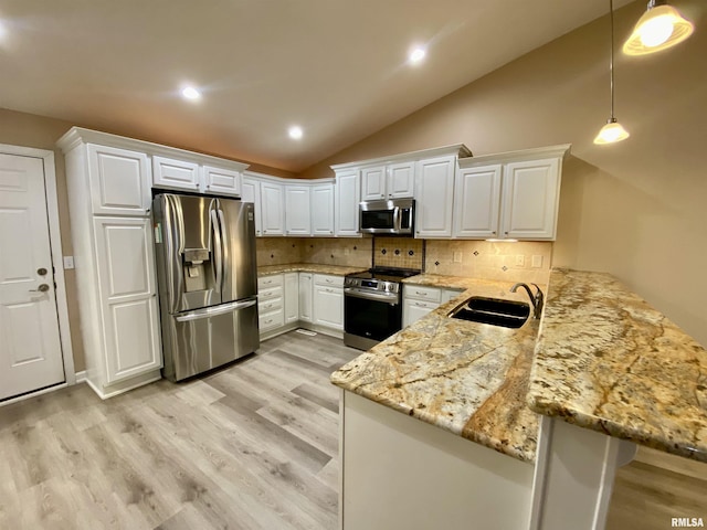 kitchen with kitchen peninsula, stainless steel appliances, decorative light fixtures, sink, and white cabinets