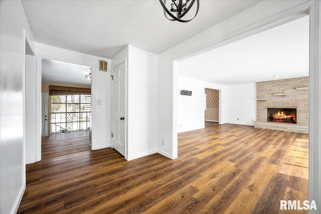 unfurnished living room with a fireplace and dark wood-type flooring