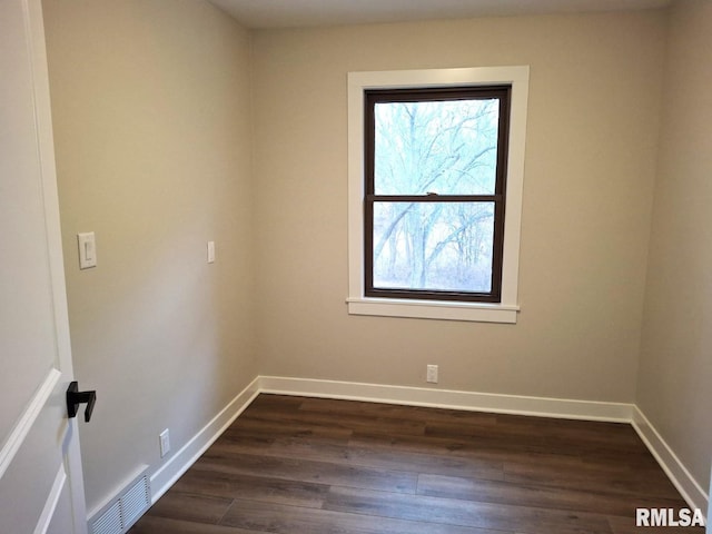 300 E 4th St, Saint David, IL 61563 - empty room featuring dark wood-style floors, visible vents, and baseboards