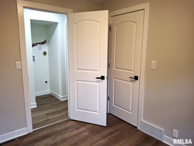 300 E 4th St, Saint David, IL 61563 - unfurnished bedroom with dark wood-style floors, visible vents, and baseboards
