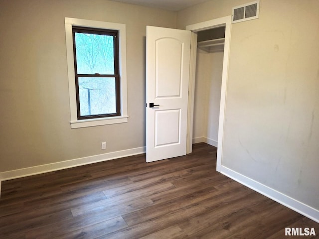 300 E 4th St, Saint David, IL 61563 - unfurnished bedroom featuring baseboards, visible vents, a closet, and dark wood-style floors