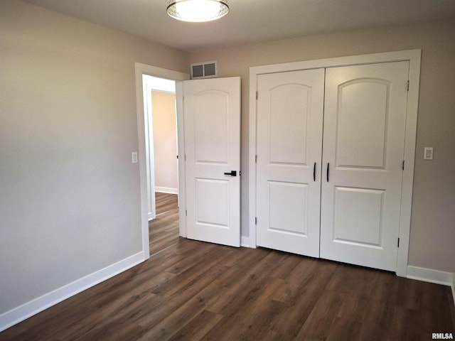 300 E 4th St, Saint David, IL 61563 - unfurnished bedroom featuring visible vents, a closet, dark wood finished floors, and baseboards