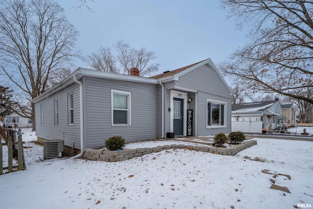 bungalow-style house with a chimney and central AC