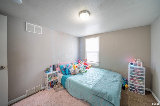 bedroom with carpet, visible vents, and a textured ceiling