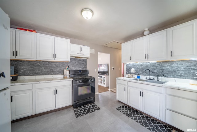 kitchen with black range with gas cooktop, under cabinet range hood, a sink, white cabinetry, and light countertops