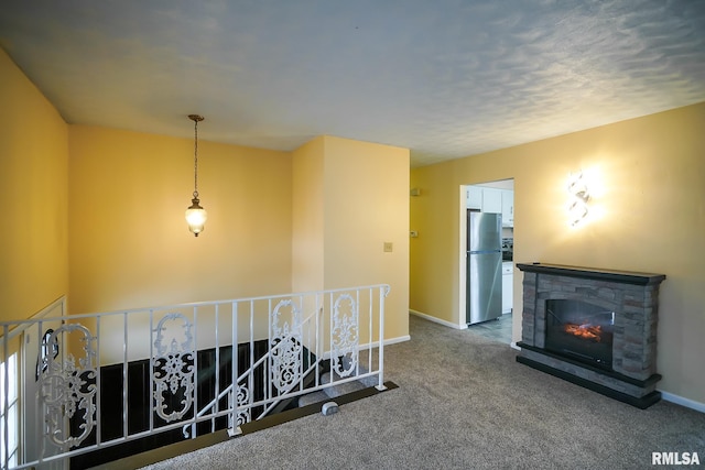 hallway featuring carpet floors, an upstairs landing, and baseboards