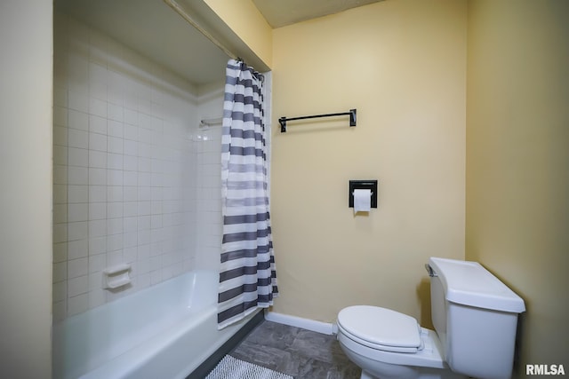 bathroom featuring toilet, shower / tub combo, and baseboards