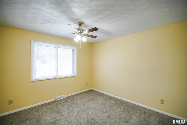 spare room with baseboards, visible vents, ceiling fan, and carpet flooring