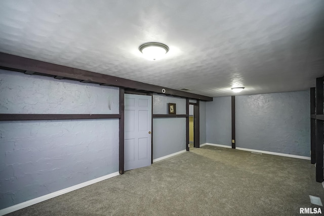 finished basement with a textured wall, carpet floors, a textured ceiling, and baseboards