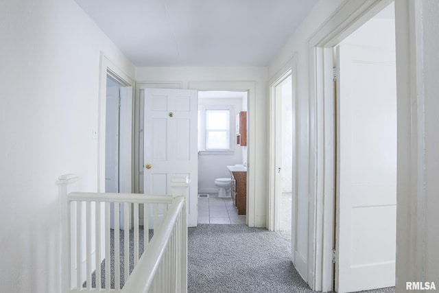 hall with carpet and an upstairs landing