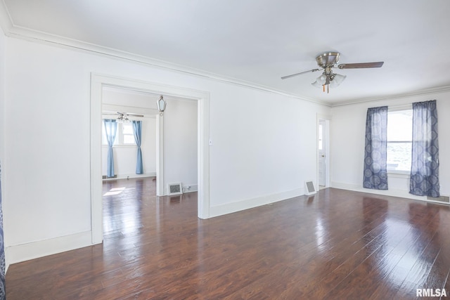 spare room with ceiling fan, dark wood-style flooring, visible vents, and crown molding