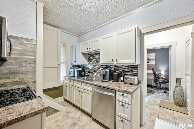 kitchen with an ornate ceiling, gas stovetop, decorative backsplash, stainless steel dishwasher, and a sink