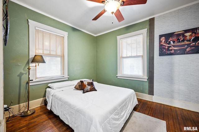 bedroom with dark wood-style flooring, crown molding, and baseboards