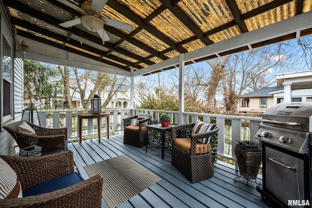 deck featuring ceiling fan and a grill