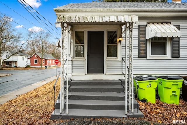 entrance to property with roof with shingles