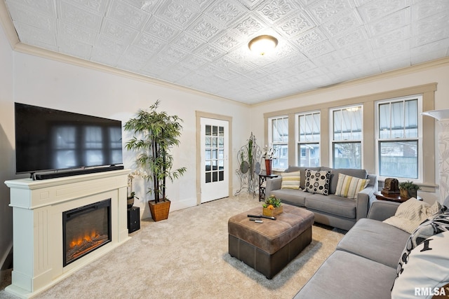 living room featuring a wealth of natural light, light colored carpet, crown molding, and a glass covered fireplace