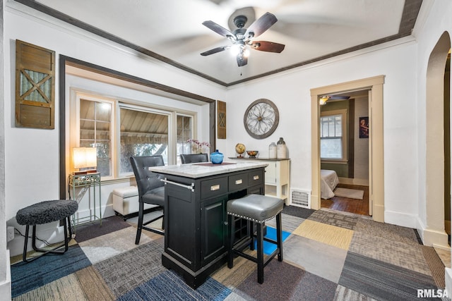 home office with arched walkways, ornamental molding, visible vents, and baseboards