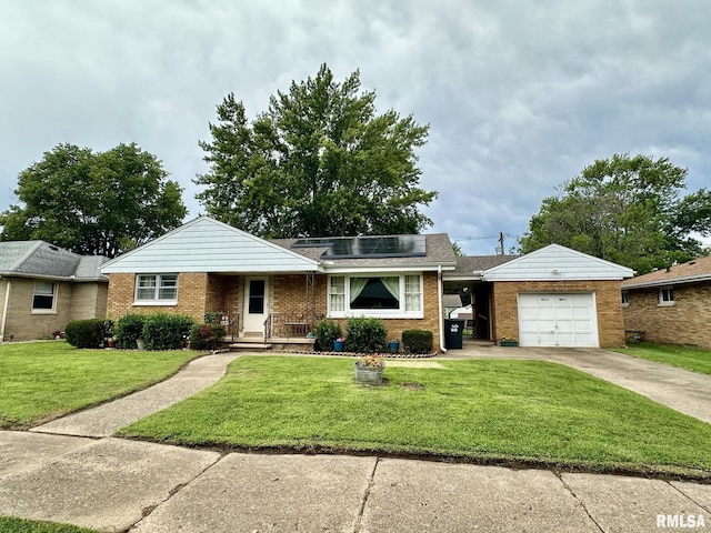 single story home featuring brick siding, an attached garage, a front yard, roof mounted solar panels, and driveway