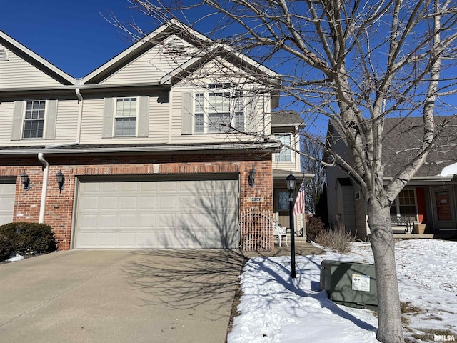 view of front facade with a garage, brick siding, and driveway