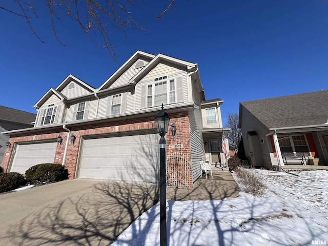 view of front of house with concrete driveway, brick siding, and an attached garage