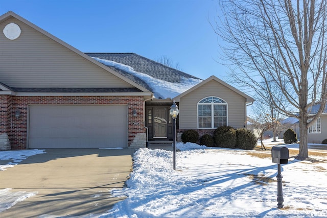 single story home featuring a garage, a shingled roof, concrete driveway, and brick siding