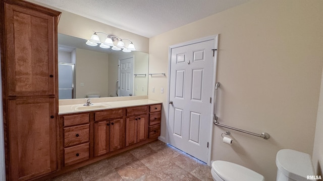 bathroom with toilet, an enclosed shower, a textured ceiling, and vanity