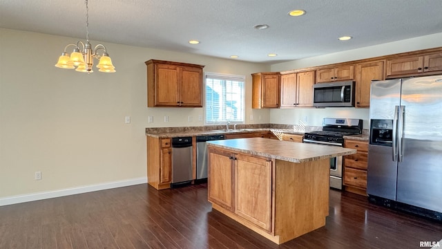 kitchen with brown cabinetry, dark wood finished floors, appliances with stainless steel finishes, a center island, and pendant lighting