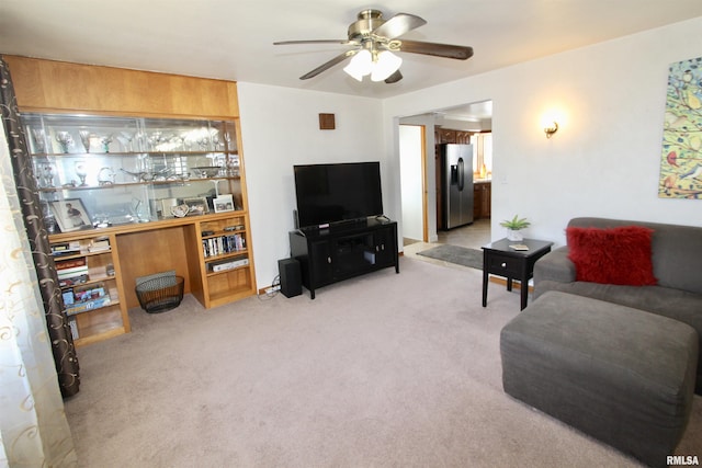 living area featuring ceiling fan and light colored carpet