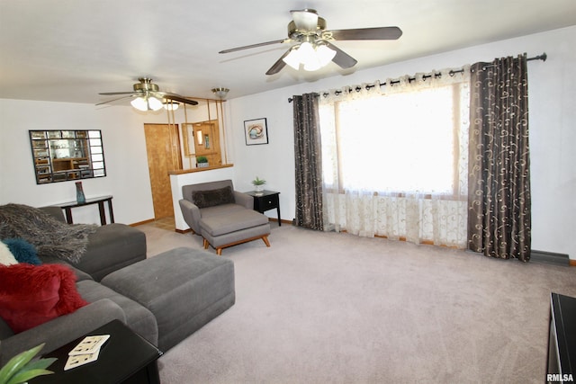 living room featuring baseboards, ceiling fan, and light colored carpet