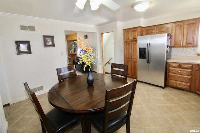 dining area with light tile patterned floors, ceiling fan, ornamental molding, and visible vents